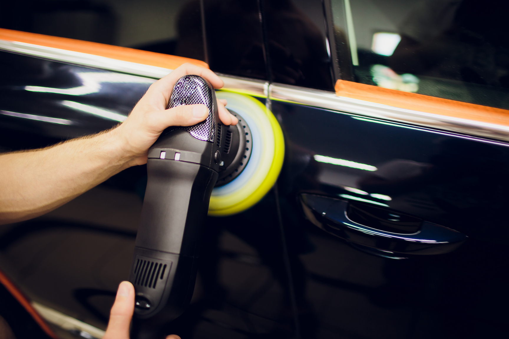 Polished black car polishing machine polished finishing. Car detailing. Selective focus.