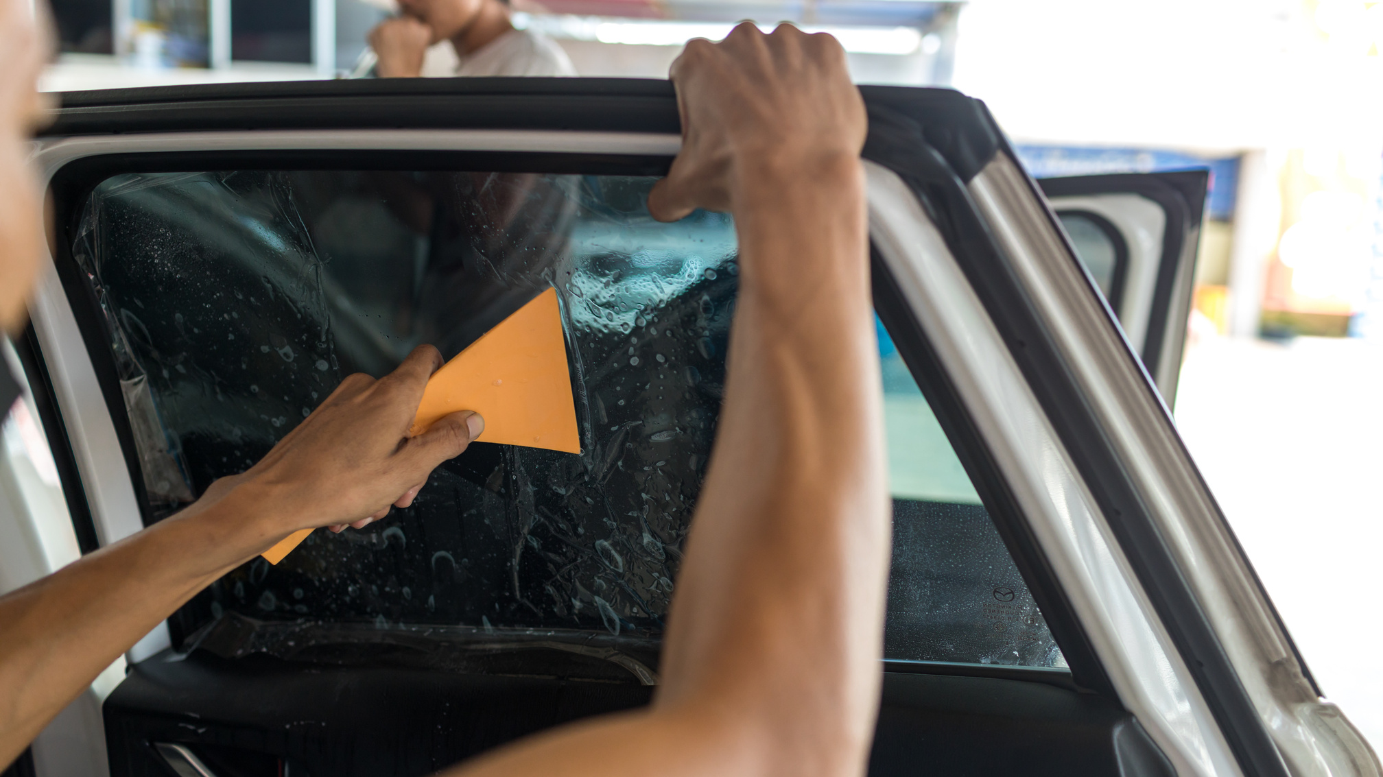 Technician Installing car window tint.